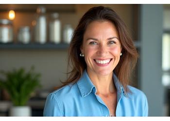 Ritratto professionale di una nutrizionista sorridente di età compresa tra 40 e 50 anni in un ambiente luminoso e pulito.